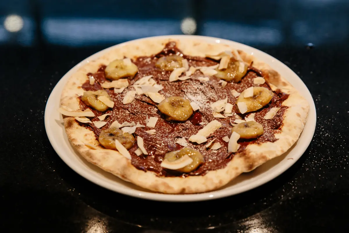 A Nutella pizza topped with strawberries and bananas.