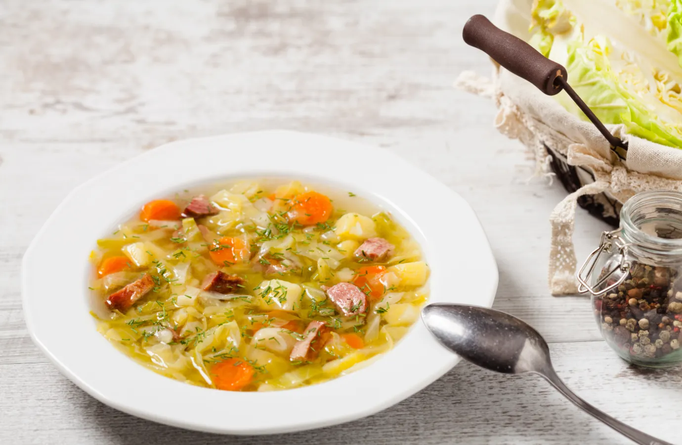 Bowl of homemade cabbage soup on rustic table.