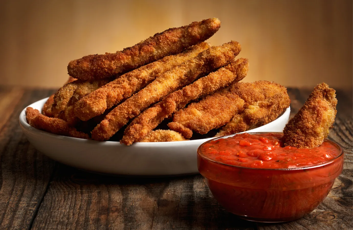 Plate of spicy buffalo chicken strips served with dipping sauce